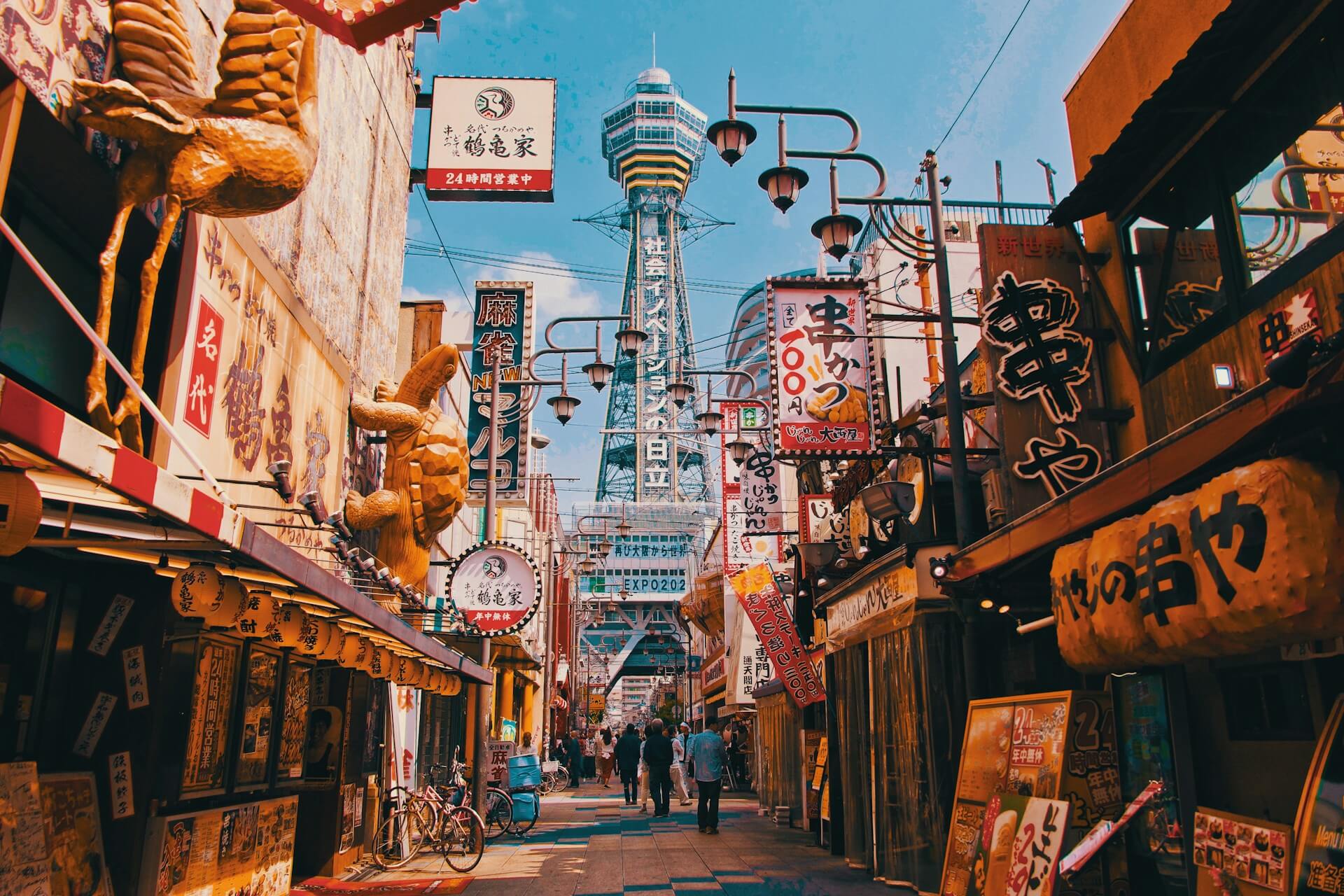 Rue animée de Shinsekai à Osaka avec la tour Tsutenkaku.